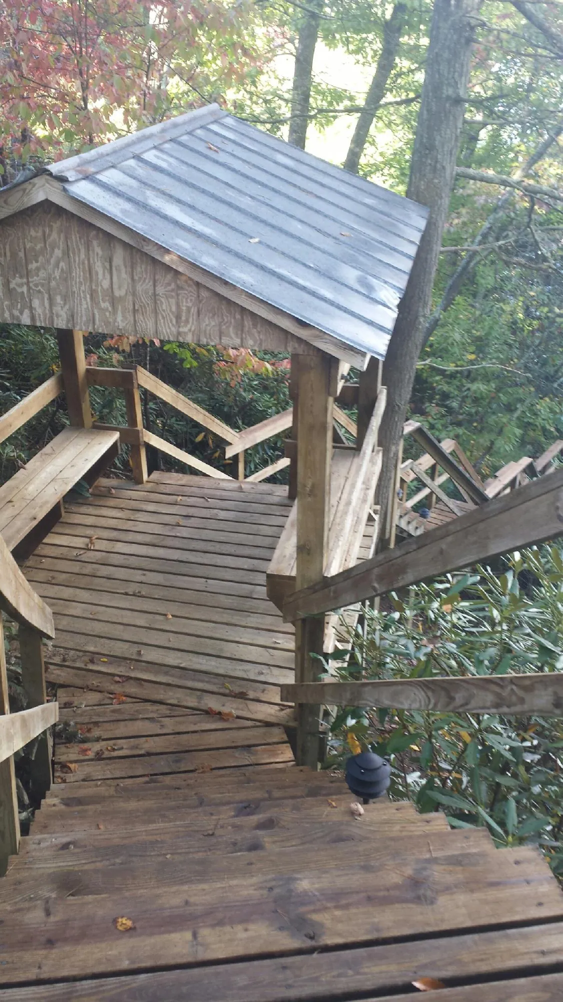 Metal roofed shelter over wooden steps on a wooded walkway — Skylight Repair & Installation work by our crew in Orrs Island