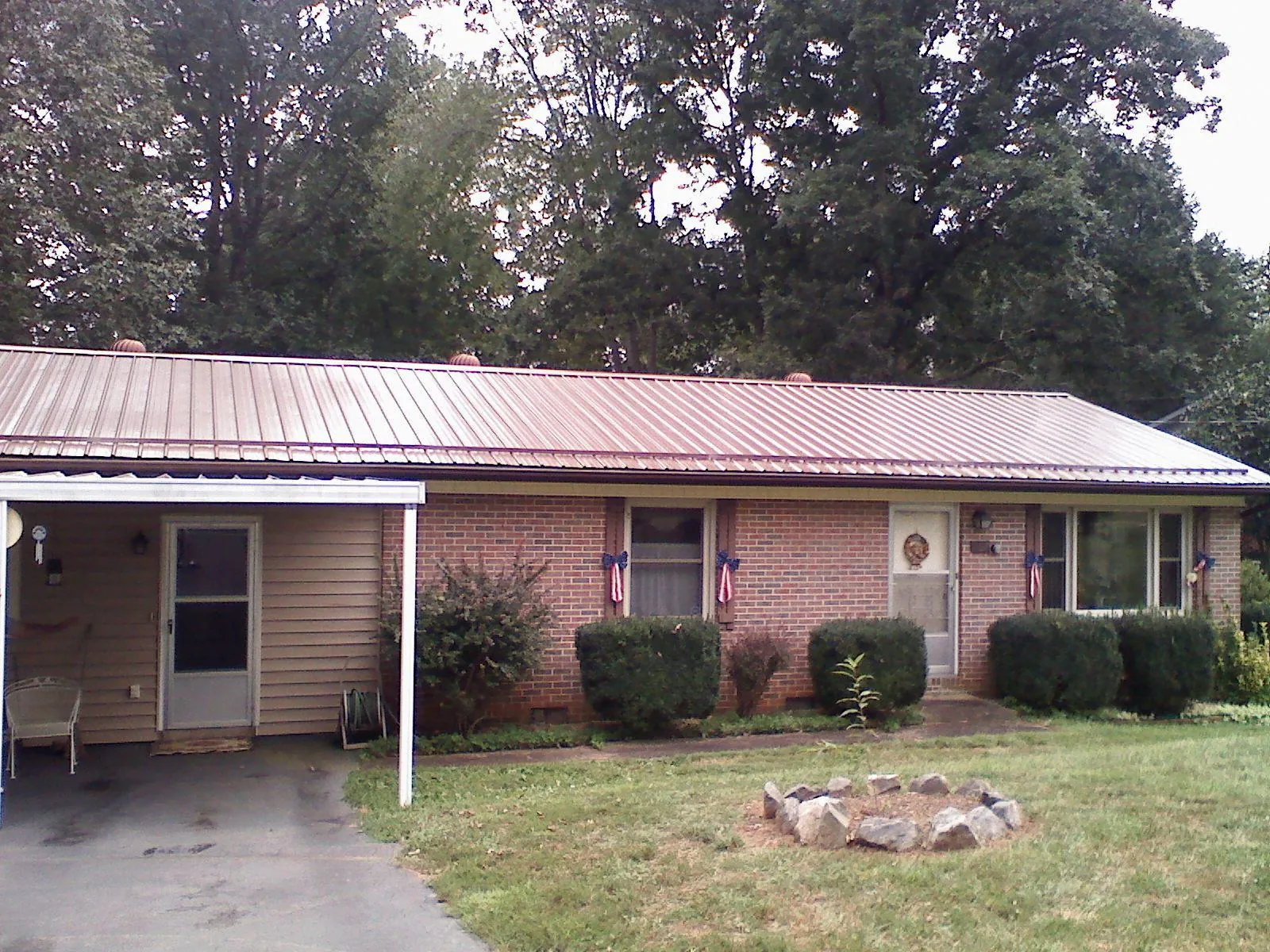 Bronze metal roof and carport on a brick ranch home — Roof Repair work by our crew in Orrs Island